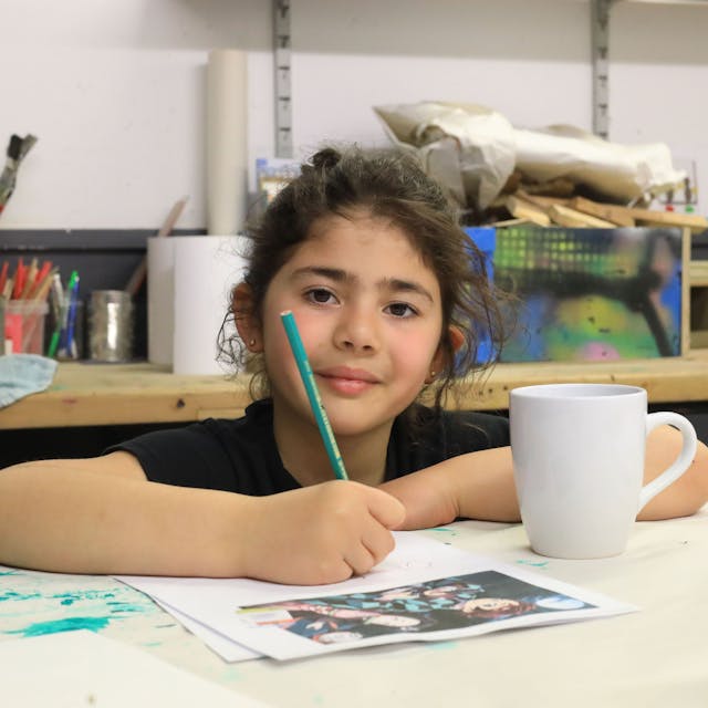Die neunjährige Ela hat Spaß bei der Arbeit. Ein Motiv ihrer Lieblingsmangaserie will sie auf die Tasse malen.