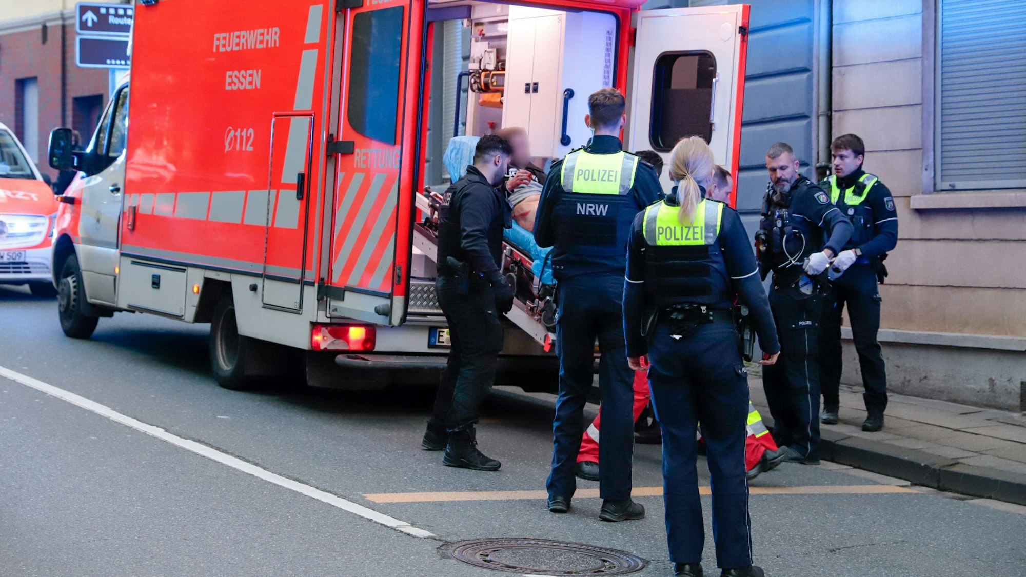 22.04.2024, Nordrhein-Westfalen, Essen: Ein Mann wird auf einer Liege in einen Krankenwagen geschoben. Bei einem Einsatz von Polizeibeamten ist es am Montagabend zum polizeilichen Schusswaffengebrauch gekommen, ein Mann wurde dabei angeschossen. Foto: Justin Brosch/dpa +++ dpa-Bildfunk +++