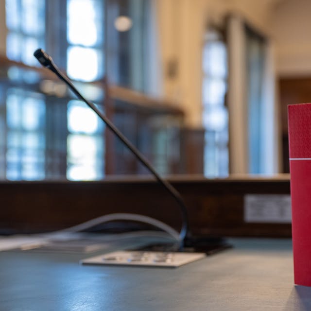 Das Gesetzbuch „Strafrecht“ steht auf einem Tisch in einem Verhandlungssaal.