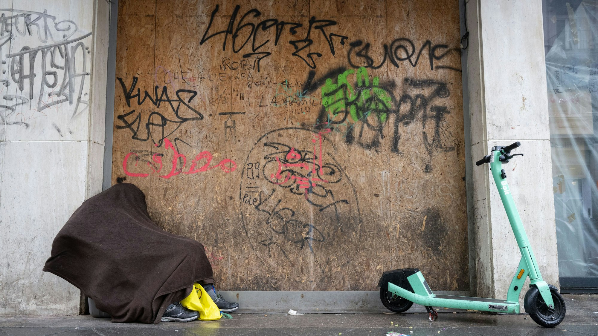 Ein obdachloser Mann sucht in einem Hauseingang Schutz.