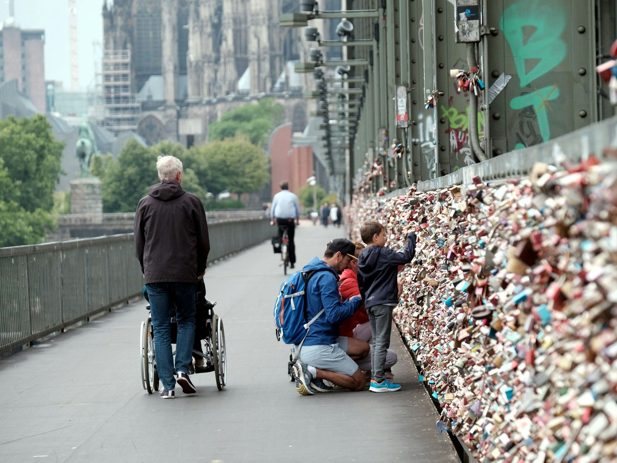 Menschen schauen sich die Liebesschlösser an der Hohenzollernbrücke an.