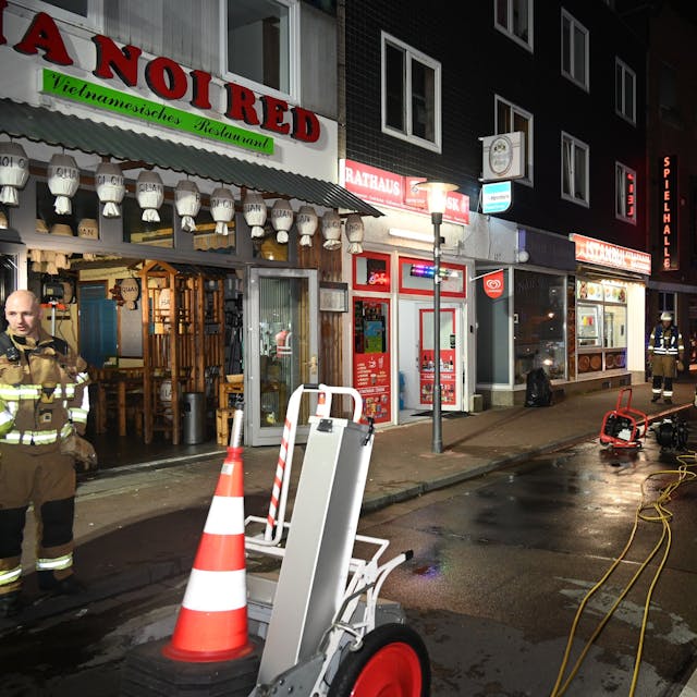 Die Einsatzkräfte der Feuerwehr vor einem Laden auf der Hauptstraße in Frechen.
