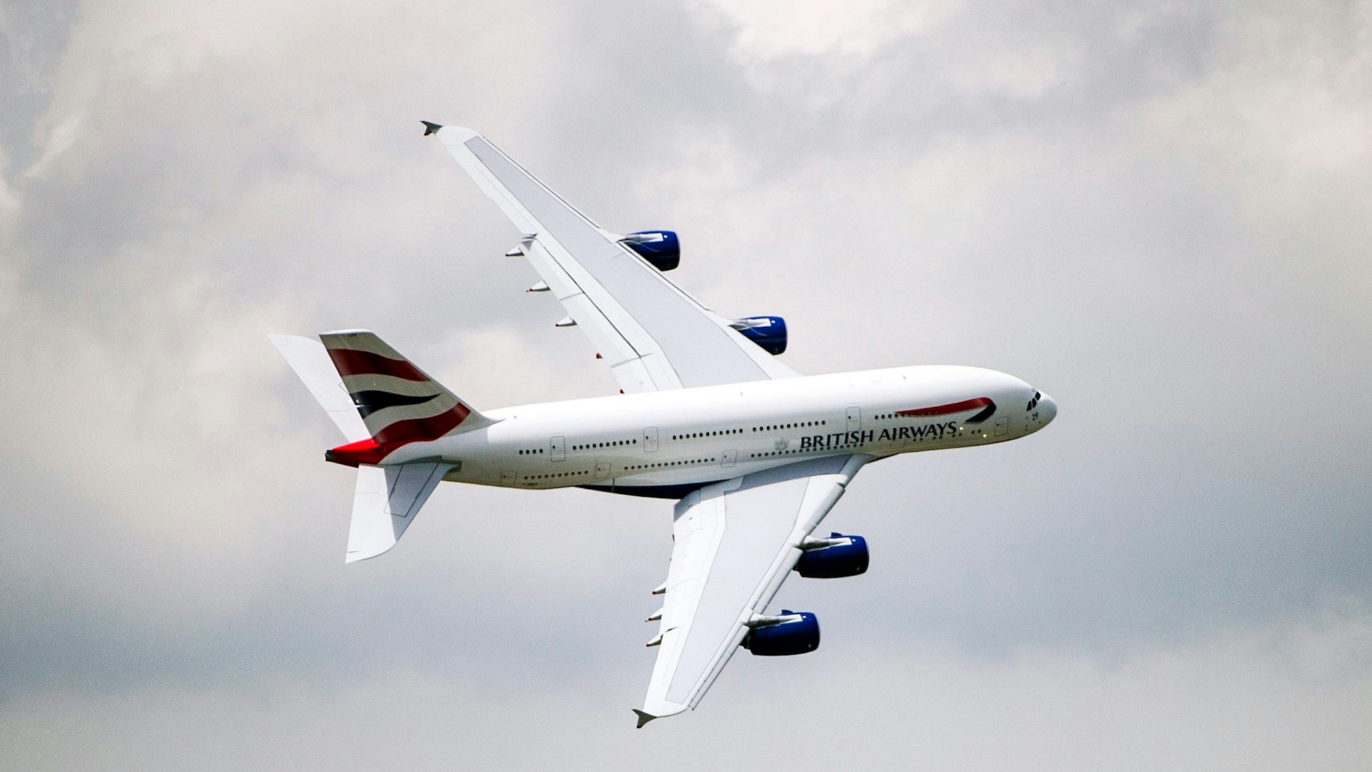 Ein Airbus A380 der britischen Fluggesellschaft British Airways fliegt vor einem Unwetter eine scharfe Kurve am Himmel. (Symbolbild)