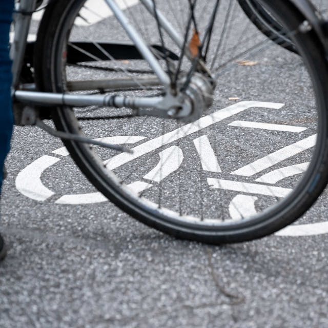 ARCHIV - 31.10.2021, Hamburg: Ein Fahrrad-Symbol ist auf der Fahrbahn einer Straße hinter einem Fahrrad zu sehen. (zu dpa: «14-jähriger Radfahrer stürzt und wird schwer verletzt») Foto: Jonas Walzberg/dpa +++ dpa-Bildfunk +++