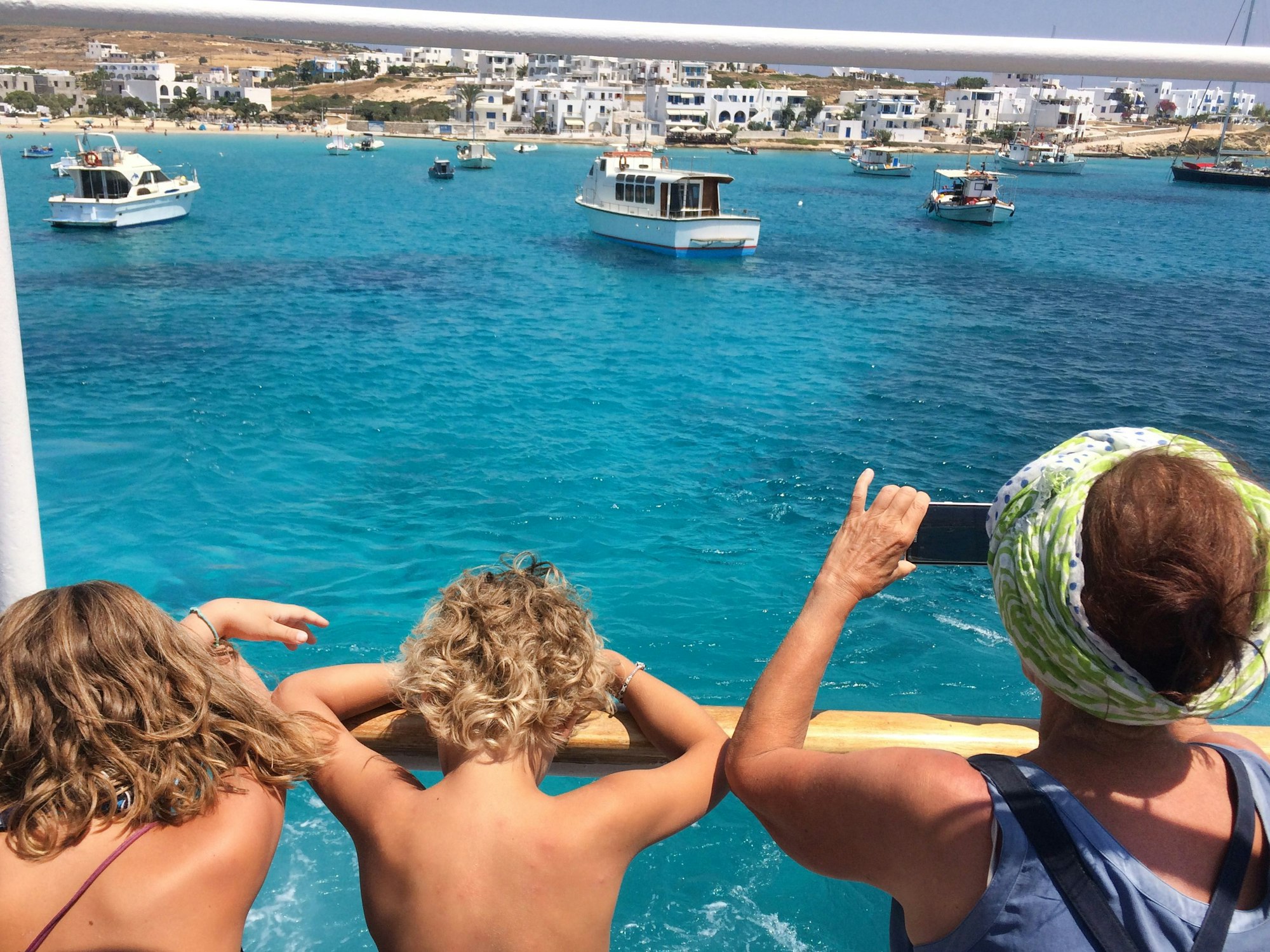 ARCHIV - Deutsche Touristen blicken am 07.08.2017 von einem Ausflugsschiff auf das türkisblaue Wasser im Hafen der Kykladen-Insel Kufonissi (Griechenland).