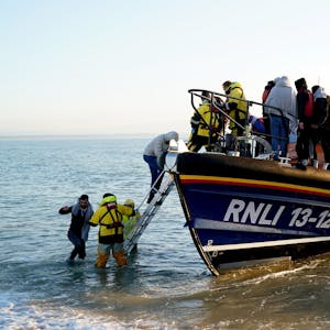 Eine Gruppe von Menschen auf einem kleinen Boot, bei denen es sich vermutlich um Migranten handelt, wird von der Royal National Lifeboat Institution (RNLI) nach einem Zwischenfall im Ärmelkanal nach Dungeness in der Grafschaft Kent gebracht. Großbritannien will illegal eingereiste Migranten künftig nach Ruanda abschieben