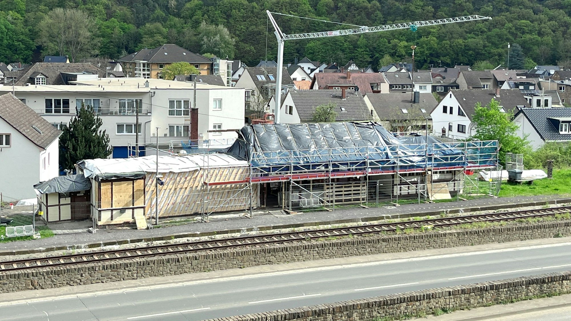 Baustelle zum Abbau des im Stadtteil Walporzheim der Stadt Bad Neuenahr-Ahrweiler gelegenen Bahnhofs. Im Vordergrund verlaufen eine Straße und die Bahnlinie, hinter dem Gebäude steht ein Baukran.