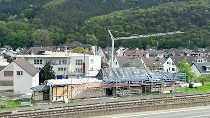 Baustelle zum Abbau des im Stadtteil Walporzheim der Stadt Bad Neuenahr-Ahrweiler gelegenen Bahnhofs. Im Vordergrund verlaufen eine Straße und die Bahnlinie, hinter dem Gebäude steht ein Baukran.