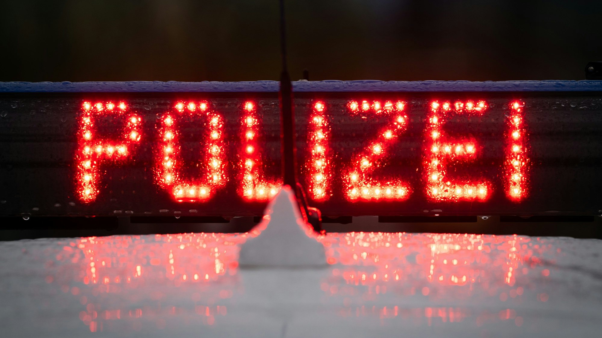 Der Schriftzug „Polizei“, leitet auf dem Dach eines Polizeiwagens.
