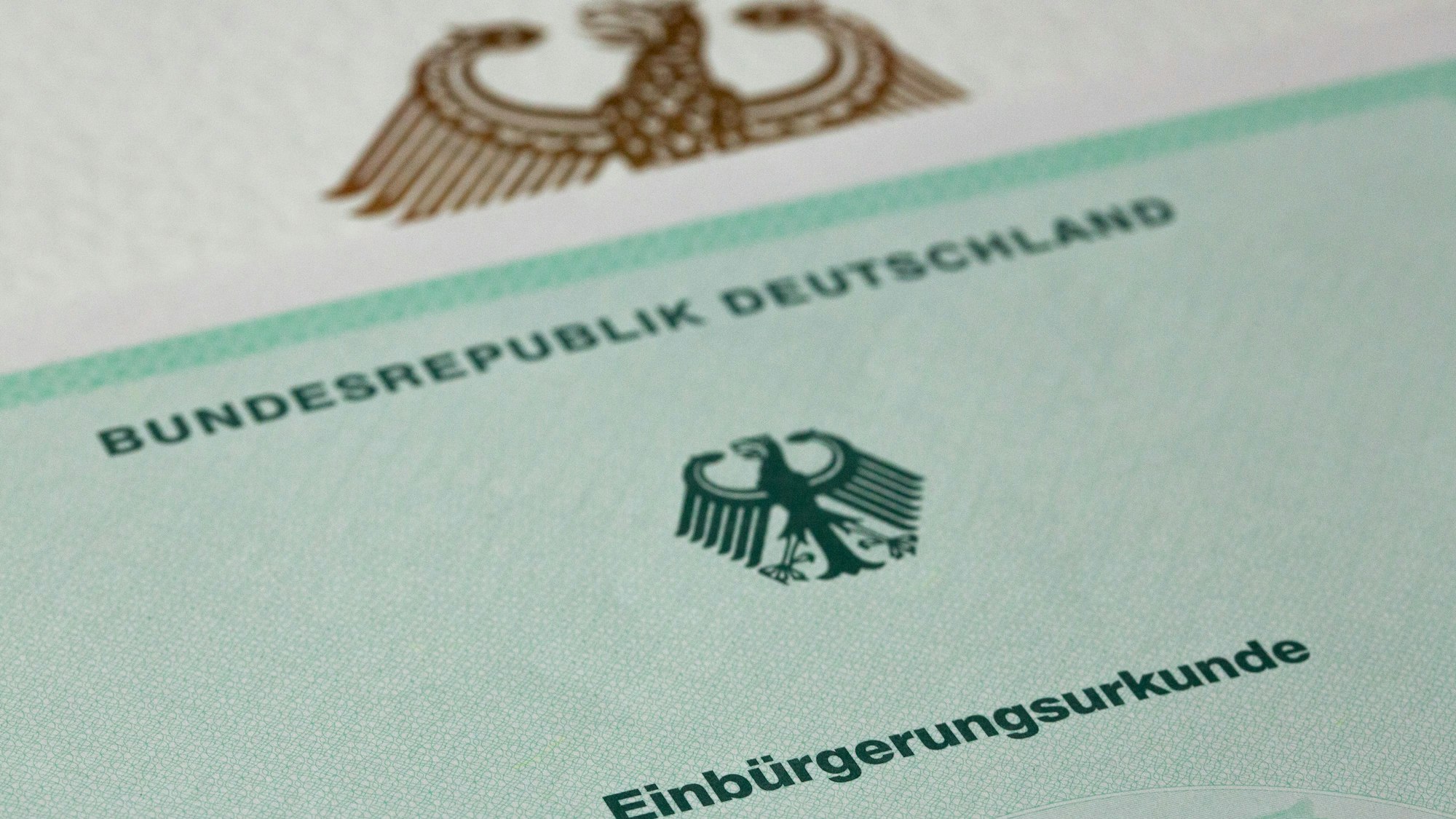 Eine Einbürgerungsurkunde der Bundesrepublik Deutschland liegt auf einem Tisch.