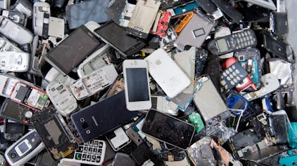Alte Handys und Smartphones liegen in einem Container, ehe sie geschreddert werden.&nbsp;