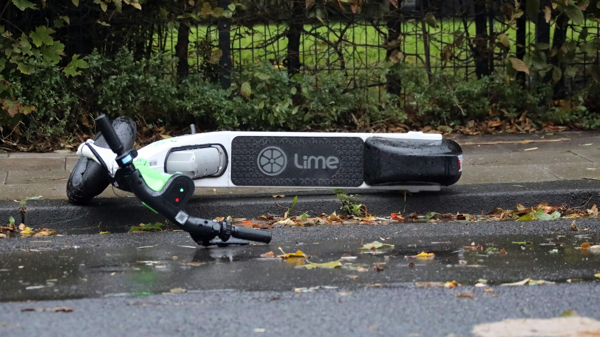 Zu sehen ist ein umgestürzter E-Scooter auf einem Bürgersteig.