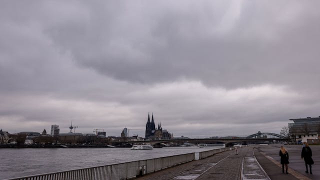 Spaziergänger bei trübem Frühjahrswetter auf der Deutzer Werft am Rhein in Köln Deutz.