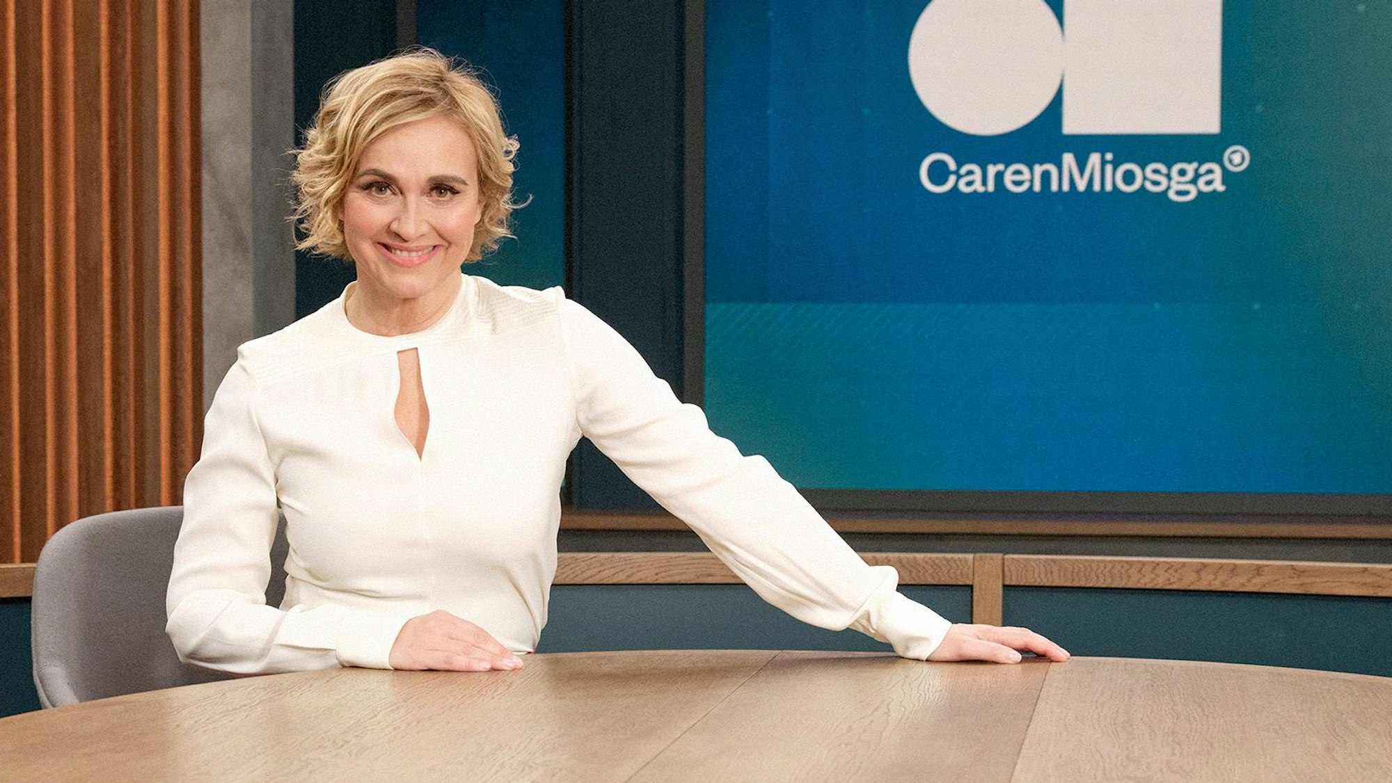 ARD-Moderatorin Caren Miosga sitz an einem Tisch im Studio ihrer gleichnamigen Talkshow, die seit Januar 2024 als Nachfolger der Talkshow von Anne Will im Ersten läuft.