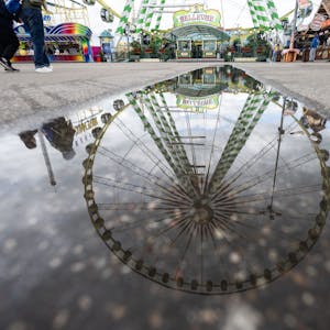 Ein Riesenrad spiegelt sich in einer Pfütze auf dem Festgelände des Stuttgarter Frühlingsfestes. Nach dem Besuch des Stuttgarter Frühlingsfestes leiden mehr als 300 Menschen unter Magen-Darm-Erkrankungen.