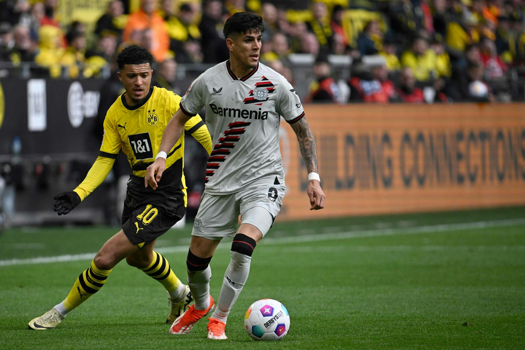 Dortmund's English midfielder #10 Jadon Sancho and Bayer Leverkusen's Ecuadorian defender #03 Piero Hincapie vie for the ball during the German first division Bundesliga football match between Borussia Dortmund and Bayer Leverkusen in Dortmund, western Germany, on April 21, 2024. (Photo by Sascha Schuermann / AFP) / DFL REGULATIONS PROHIBIT ANY USE OF PHOTOGRAPHS AS IMAGE SEQUENCES AND/OR QUASI-VIDEO