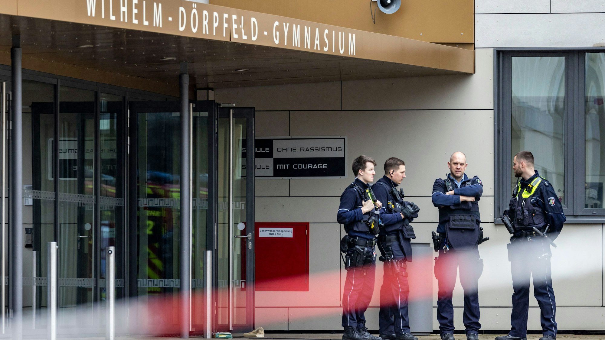 Polizeibeamte stehen vor dem Wilhelm-Dörpfeld-Gymnasium. In Wuppertal sind an einem Gymnasium mehrere Schüler verletzt worden. Ein Verdächtiger sei festgenommen worden, sagte ein Polizeisprecher in Düsseldorf. Die Polizei sei mit starken Kräften vor Ort. (zu dpa: «Nach Amoktat wieder Unterricht an Wuppertaler Gymnasium») +++ dpa-Bildfunk +++