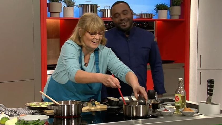 Annemarie Lamß (62) kocht sich in der ZDF-Show „Die Küchenschlacht“ in die Herzen des Publikums – und in das von Moderator Nelson Müller. Auf dem Bild sind die beiden lachend am Herd zu sehen.