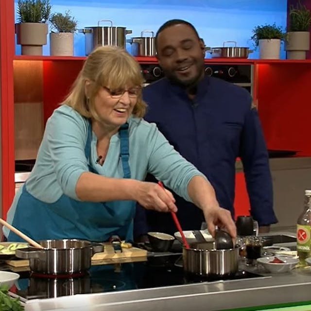 Annemarie Lamß (62) kocht sich in der ZDF-Show „Die Küchenschlacht“ in die Herzen des Publikums – und in das von Moderator Nelson Müller. Auf dem Bild sind die beiden lachend am Herd zu sehen.