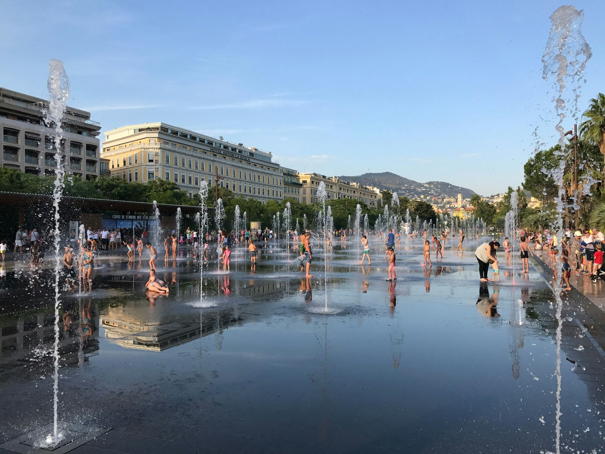 Die Promenade du Paillon in Nizza – mehrere Leute stehen im Wasser eines Brunnens.