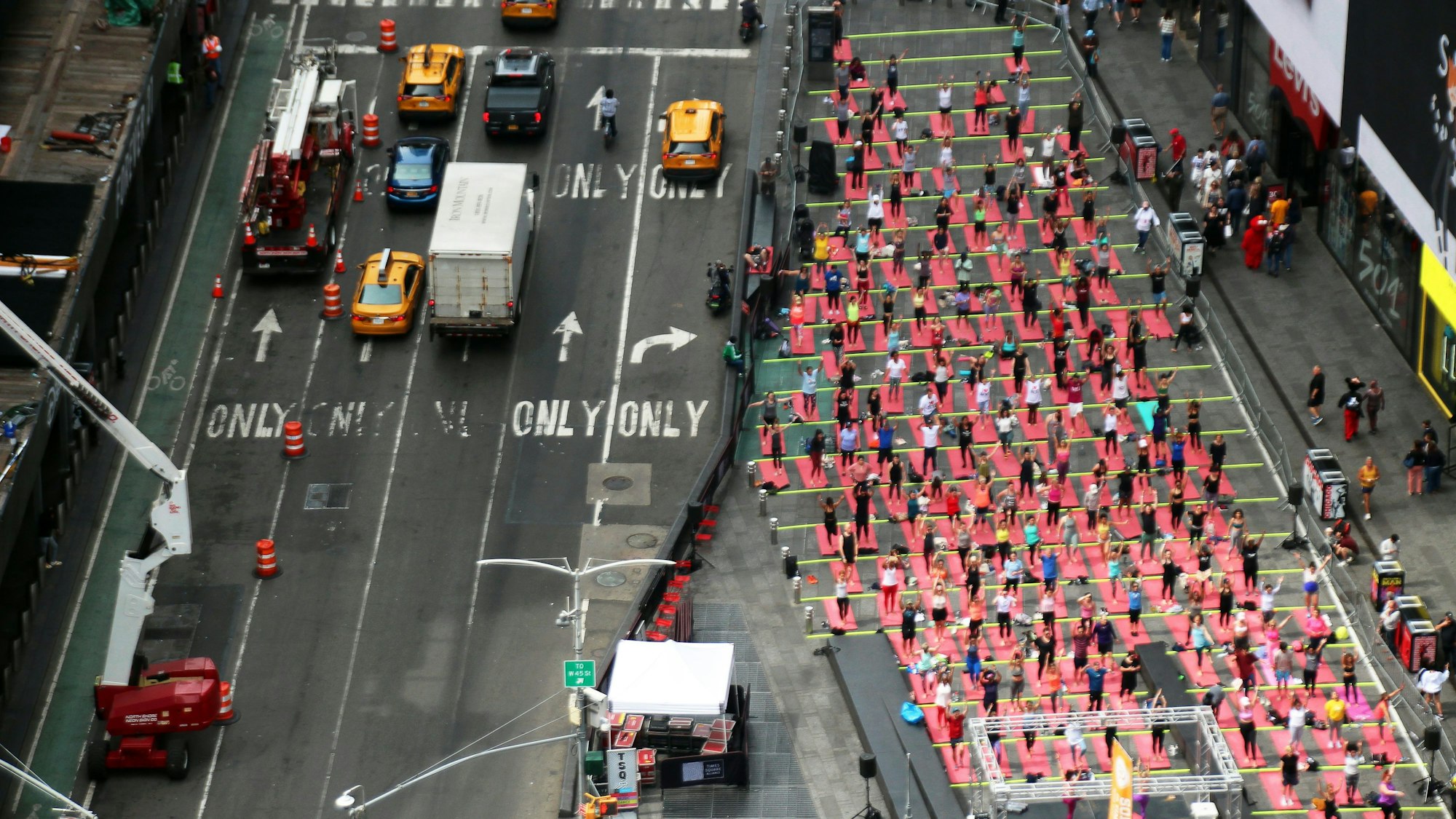 Hunderte Menschen praktizieren 2023  auf dem Times Square anlässlich des Welt-Yoga-Tags Massen-Yoga.