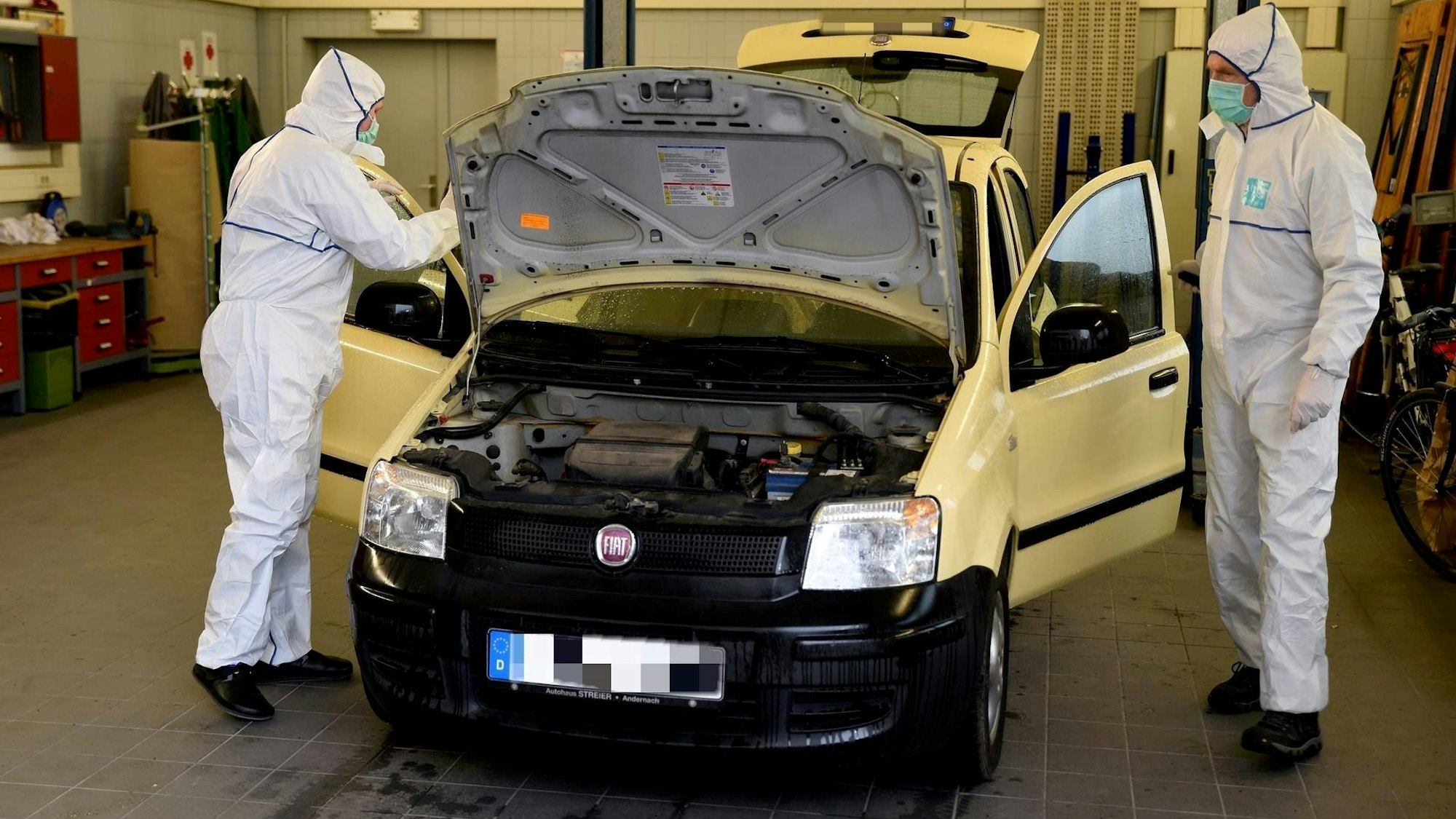 Beamte der Spurensicherung untersuchen den Fiat Panda, in dem eine Frau erschossen wurde.