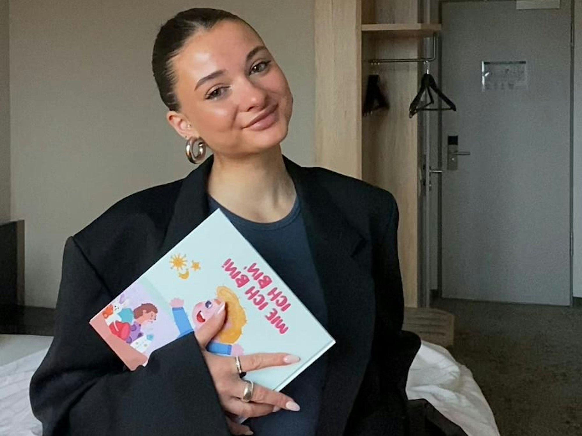Die Kölnerin Lena Gerhard hält ihr Buch „Ich bin, wie ich bin“ in der Hand.