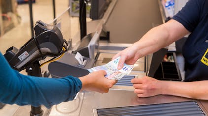Symbolfoto: 18.09.2018, Schleswig-Holstein, Flensburg: In einem Supermarkt hebt eine Kundin beim Bezahlen Bargeld ab.&nbsp;