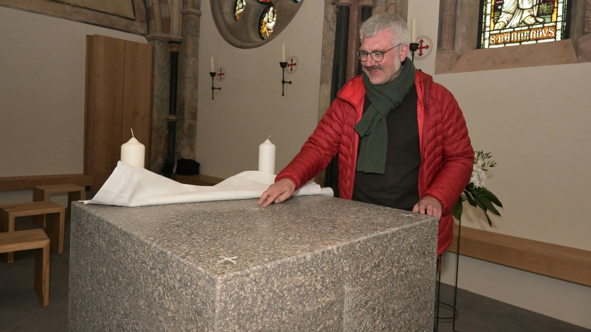 Pfarrer Thomas Taxacher am neuen Altar aus Muschelkalk.