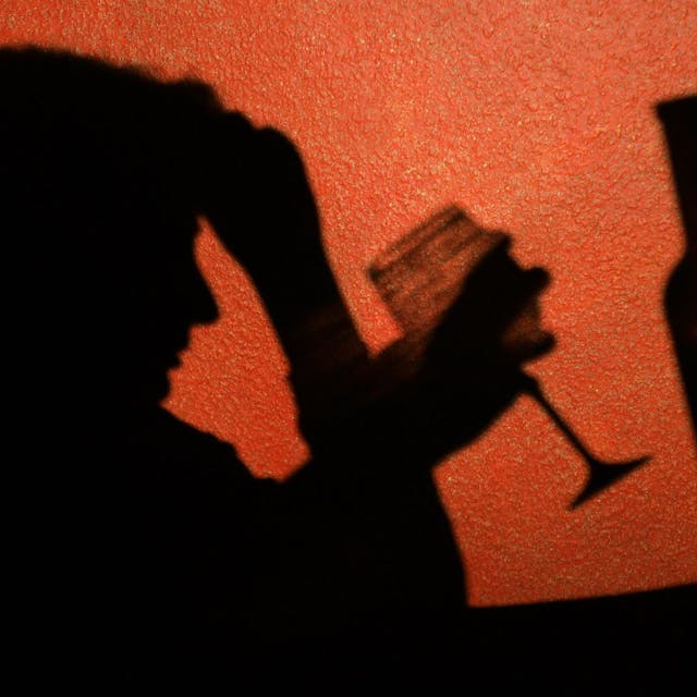Der Schatten einer Frau, die ein Glas Wein trinkt, ist an der Wand in einer Kneipe in Frankfurt (Oder) zu erkennen.  Laut einer aktuellen Studie sterben Alkoholabhängige deutlich früher.&nbsp;