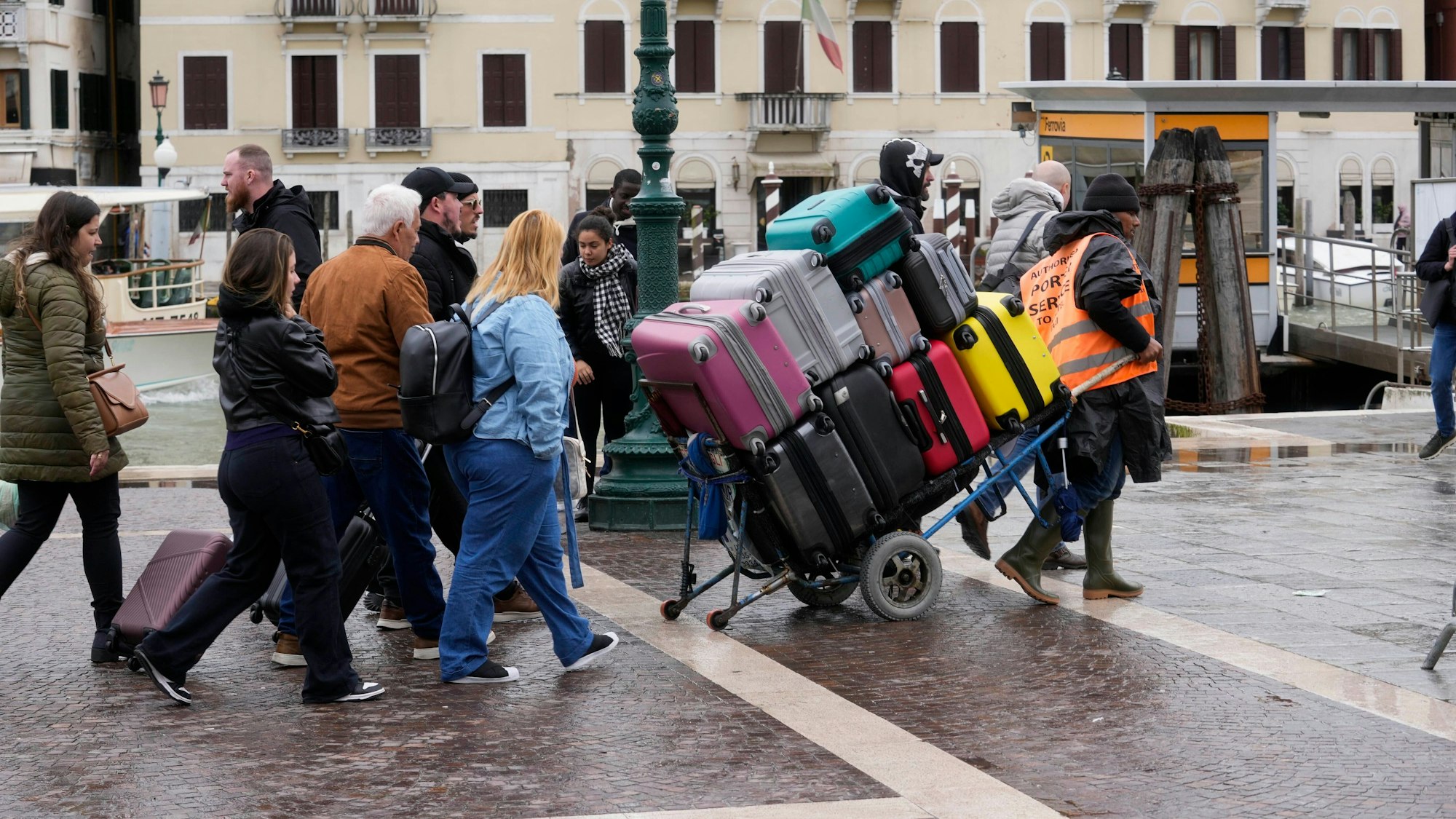 Ein Gepäckträger trägt Touristengepäck vor dem Hauptbahnhof. In Venedig, einem der meistbesuchten Reiseziele der Welt, müssen Touristen an diesem Donnerstag erstmals Eintritt bezahlen.