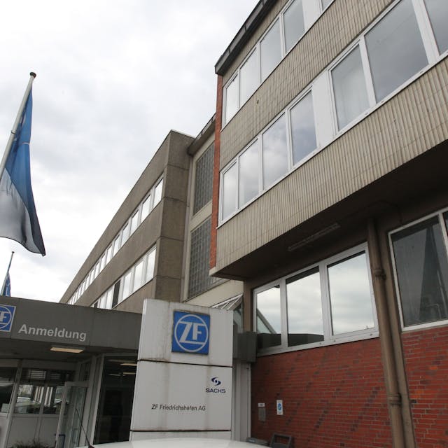 Ein altes Gebäude aus Klinker und Beton, vor dem EIngang mit dem ZF-Logo weht eine Fahne.
