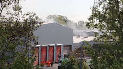 Über einer Lagerhalle auf dem RSAG-Wertstoffhof an der Josef-Kitz-Straße ist nach einem Brand Rauch zu sehen.