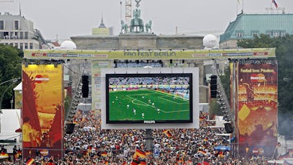 Tausende Zuschauer verfolgen auf der Fanmeile am Brandenburger Tor in Berlin das WM-Fußballspiel zwischen Deutschland und Argentinien.
