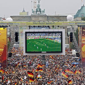 Tausende Zuschauer verfolgen auf der Fanmeile am Brandenburger Tor in Berlin das WM-Fußballspiel zwischen Deutschland und Argentinien.