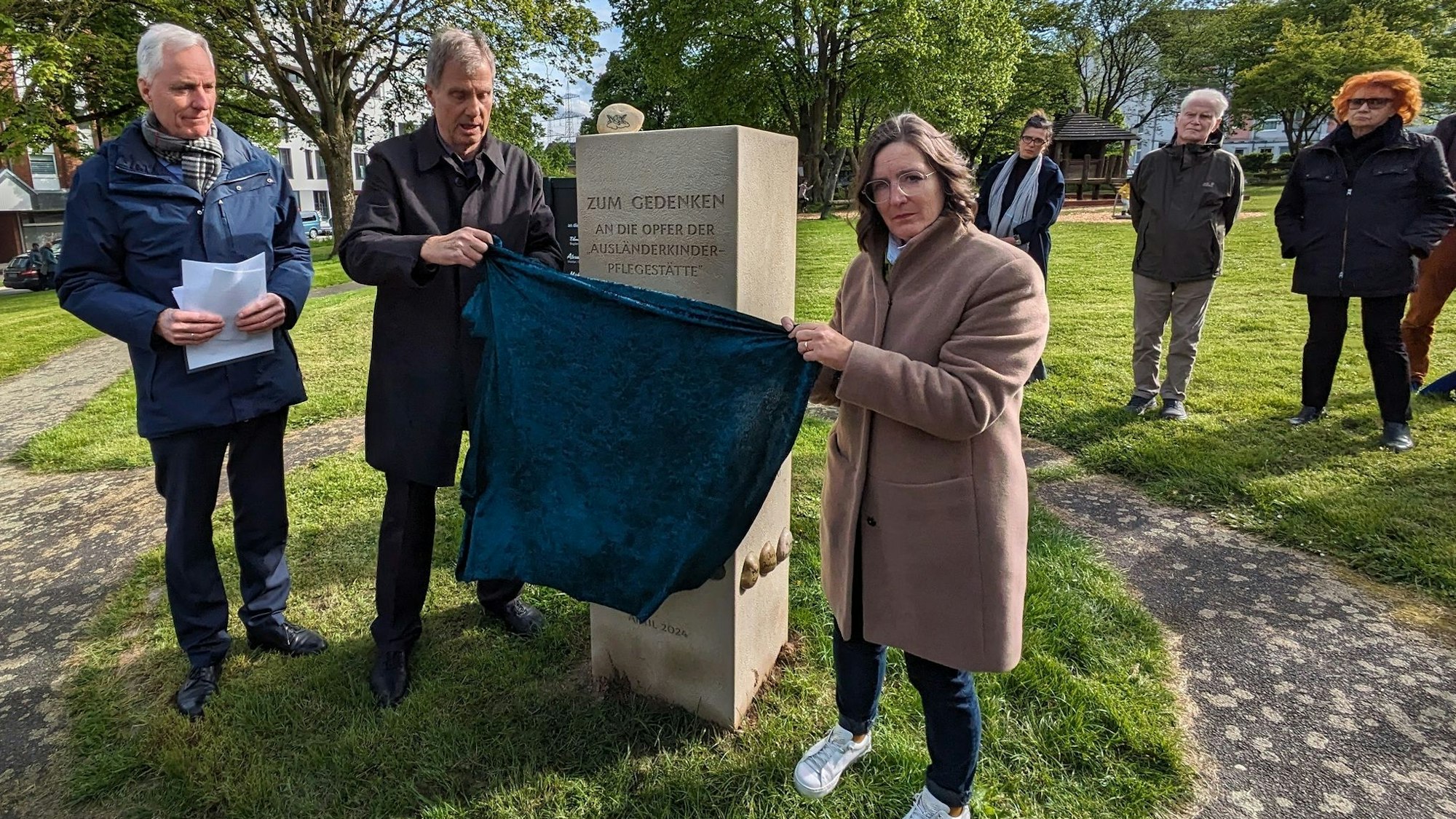 Die Gedenkstätte für die Opfer der sogenannten "Ausländerkinder-Pflegestätte" in Alfter wurde offiziell vor dem Rathaus enthüllt durch Thomas Klaus (2. von links) und Jeanette Schroerlücke (vorne rechts).