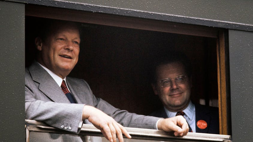 Willy Brandt steht am geöffneten Fenster eines Zuges, auf dem Bild rechts steht sein Referent Günter Guillaume. Beide blicken aus dem Fenster.