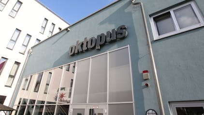 Das Schwimmbad Oktopus in Siegburg: Eine blaue Hausfassade mit Fensterfront und Logo.
