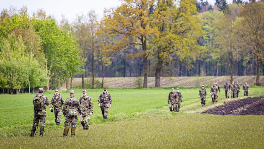 Soldaten der Bundeswehr suchen ein Feld ab.