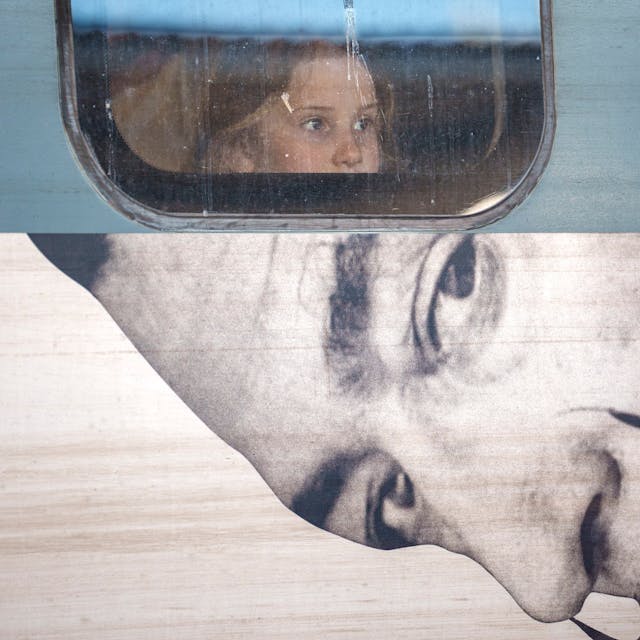 A child looks out from the window of a train displaying an advert to a Salvador Dali exhibition, at Gara de Nord, the main railway station in Bucharest, Romania,&nbsp;