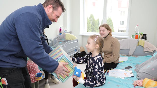 Thomas Migenda von der Humanitären Hilfe Overath überreicht einem Kind in der Kinderklinik Lviv ein Geschenk.
