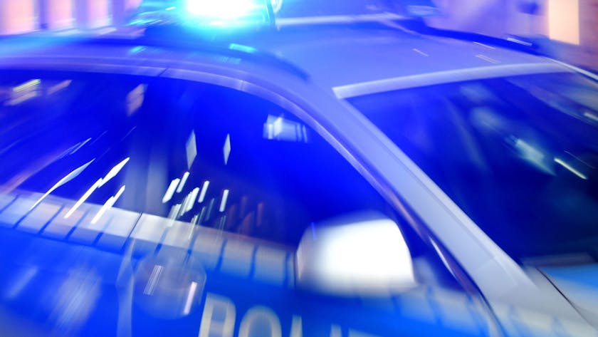 Ein Streifenwagen der Polizei steht mit eingeschaltetem Blaulicht auf der Straße. (Symbolbild)
