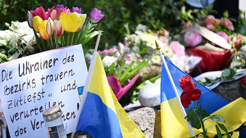 Neben dem Einkaufszentrum an dem am Samstagabend zwei Männer aus der Ukraine getötet worden sind, haben Menschen Blumen und Plakate niedergelegt. Die beiden getötete Ukrainer waren Armeeangehörige.