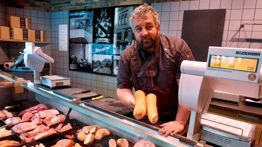Zu sehen ist Metzger Markus Kleesattel hinter der Fleischereitheke.