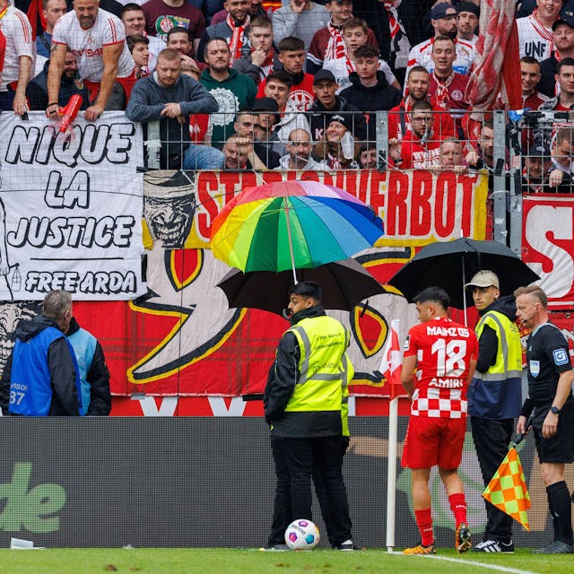Mainz-Profi Nadiem Amiri wird bei seinem zweiten Versuch, eine Ecke auszuführen mit Schirmen geschützt.