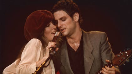 Stevie Nicks und Lindsey Buckingham von der Band Fleetwood Mac teilen sich auf der Bühne des Civic Center in Providence, Rhode Island ein Mikrofon. Die Aufnahmen stammt aus den 1970er Jahren.