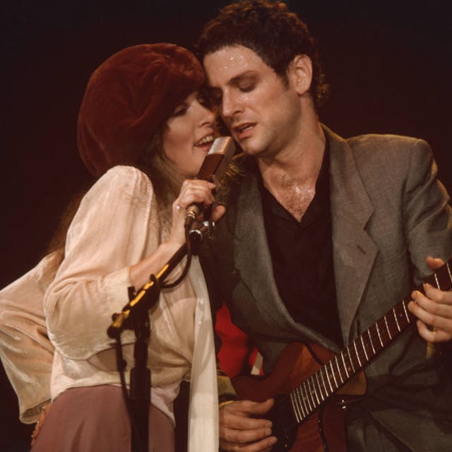 Stevie Nicks und Lindsey Buckingham von der Band Fleetwood Mac teilen sich auf der Bühne des Civic Center in Providence, Rhode Island ein Mikrofon. Die Aufnahmen stammt aus den 1970er Jahren.
