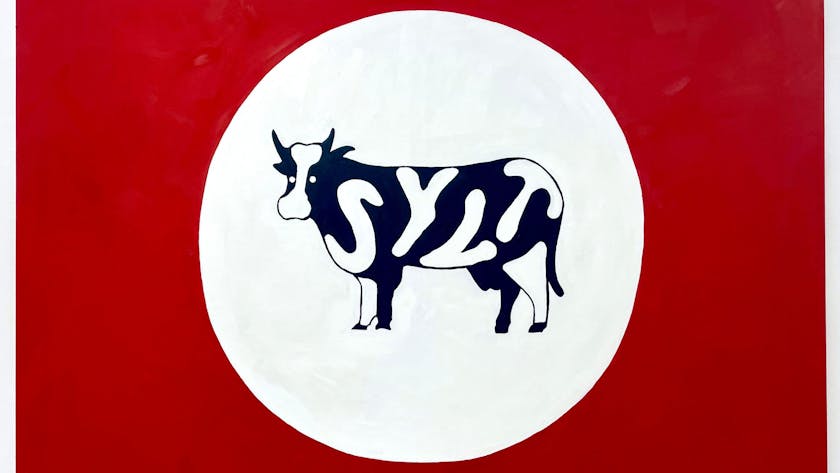 Eine Kuh mit dem Schriftzug Sylt steht in einem weißen Kreis vor einem roten Hintergrund.&nbsp;