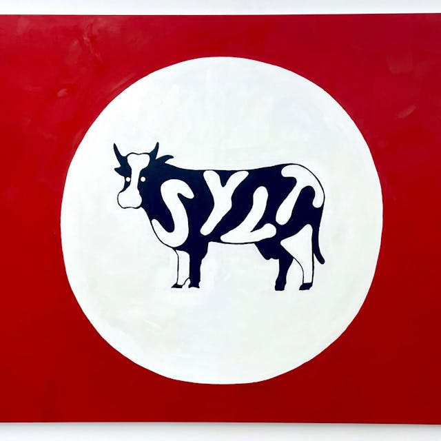 Eine Kuh mit dem Schriftzug Sylt steht in einem weißen Kreis vor einem roten Hintergrund.&nbsp;