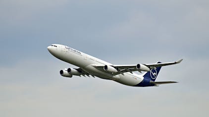 Ein Airbus A340 der deutschen Fluggesellschaft Lufthansa startet inmitten grauer Wolken. Das Flugzeug ist markant in weiß und blau lackiert. (Symbolbild)